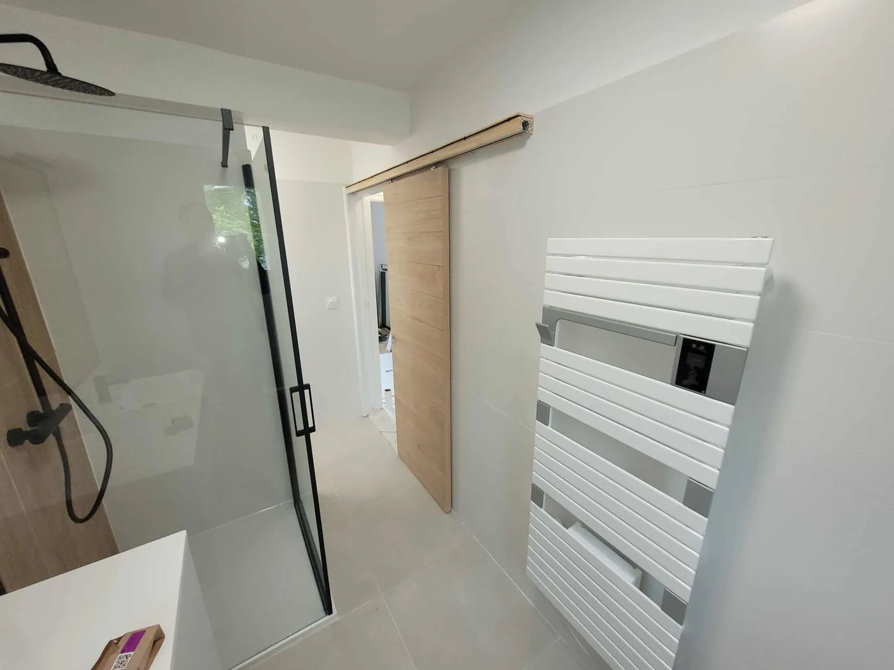 Douche avec paroi noire et porte coulissante réalisée par BLPA