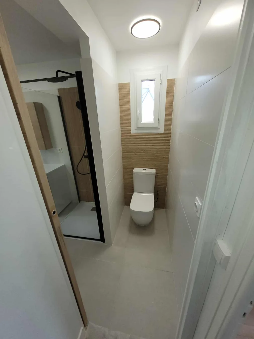 Salle de bain rénovée avec douche et espace toilettes par BLPA